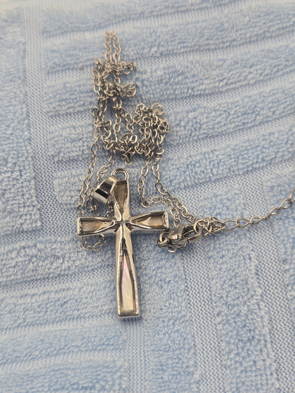 silver-toned cross necklace features a distinct baguette crystal inset,
